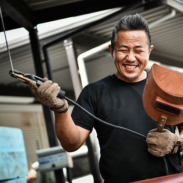 笑顔を見せる看板職人の画像